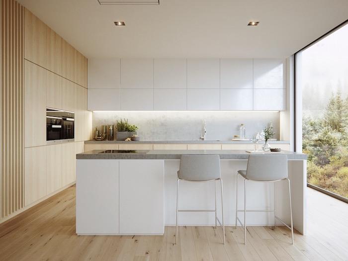 مطبخ خشبي وأبيض مع خزائن منخفضة وأعمدة خشبية ، جزيرة مركزية بيضاء مع سطح عمل رمادي ، رشاش رمادي فاتح ، تصميم معاصر