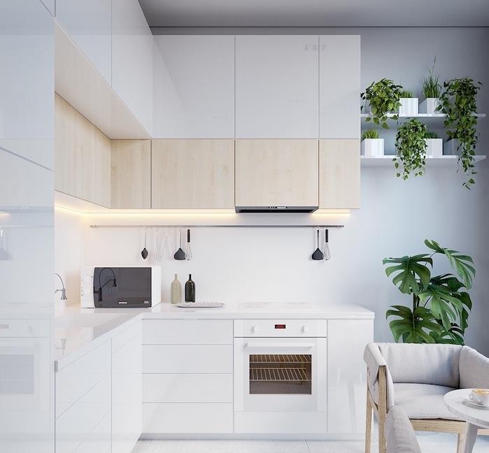 نموذج مطبخ أبيض مع خزانة منخفضة بيضاء وخزانة مرتفعة بيضاء وخشب فاتح ورذاذ أبيض ونباتات خضراء على الرف