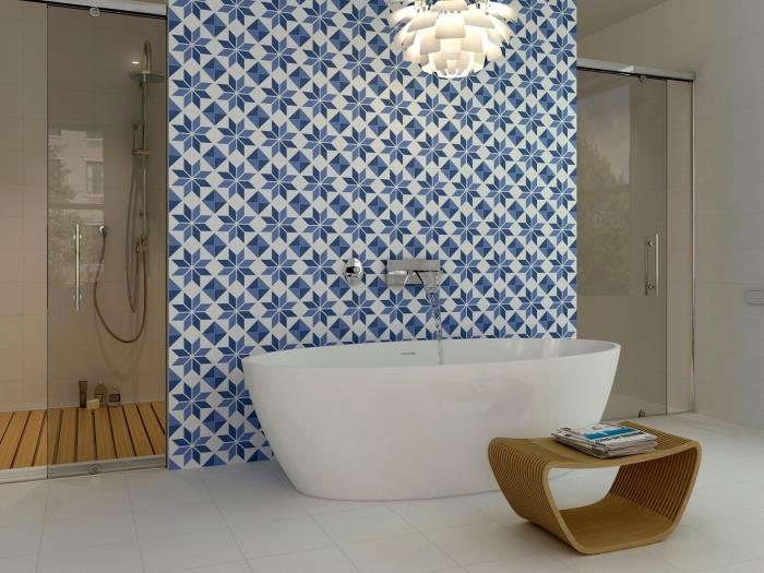 kúpeľňové cementové dlaždice umiestnené za vaňou, ktoré prebúdzajú rafinovanú atmosféru svojimi retro modrými vzormi sedmokrásky