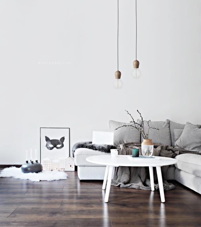 Severský nápad na interiér so škandinávskym nábytkom, bielou pohovkou a konferenčným stolíkom, tmavohnedými parketami, škandinávskou výzdobou, priemyselnými závesnými svetlami