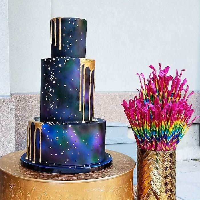 galaxia na torte, model, so zlatou polevou na fialovom, modrom a zelenom koláči, biele akcenty