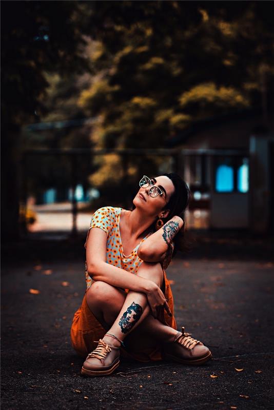 myšlienka farebného ženského tetovania na spodnej časti nohy predstavujúceho ženskú tvár so starodávnym dizajnom