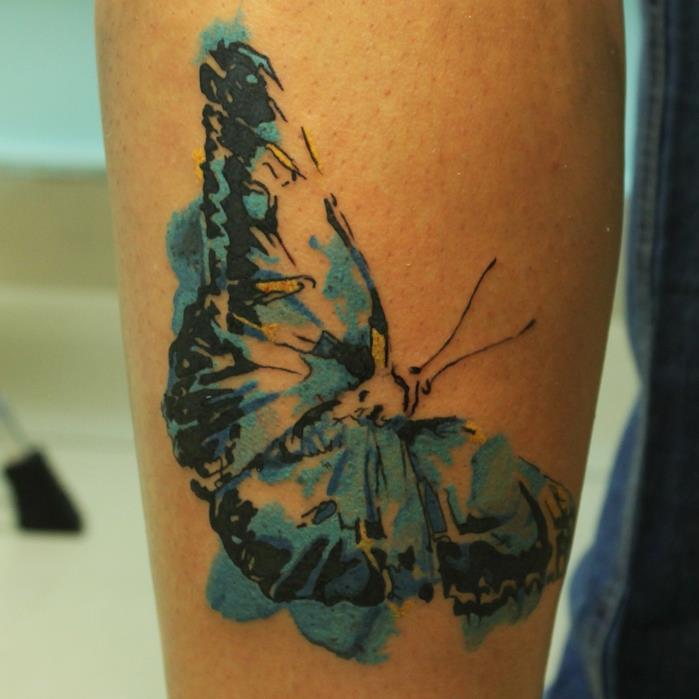 motýľové tetovanie, kresba tušom na nohe, motýľ v čiernej a zelenej farbe, dočasné tetovanie