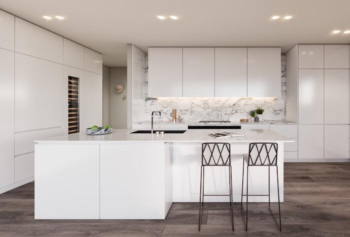 utrustat kök med köksutrustning och vit centralö, mörkbrun parkett, marmorstänk