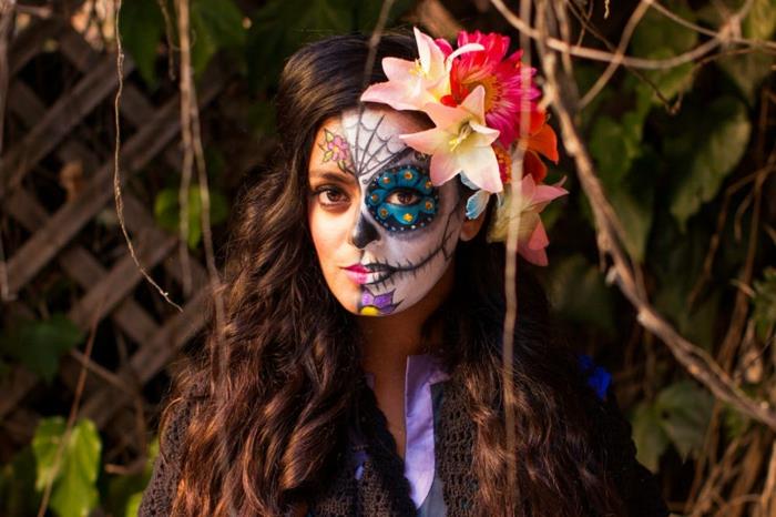 dievča v prestrojení, karnevalové líčenie, kvety vo vlasoch, polovičná make -upová tvár, halloweenske líčenie farebnej kostry