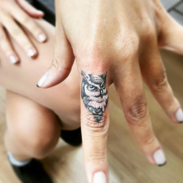 liten uggla tatuerad på fingret, tatuering på fingret i minimalistisk stil