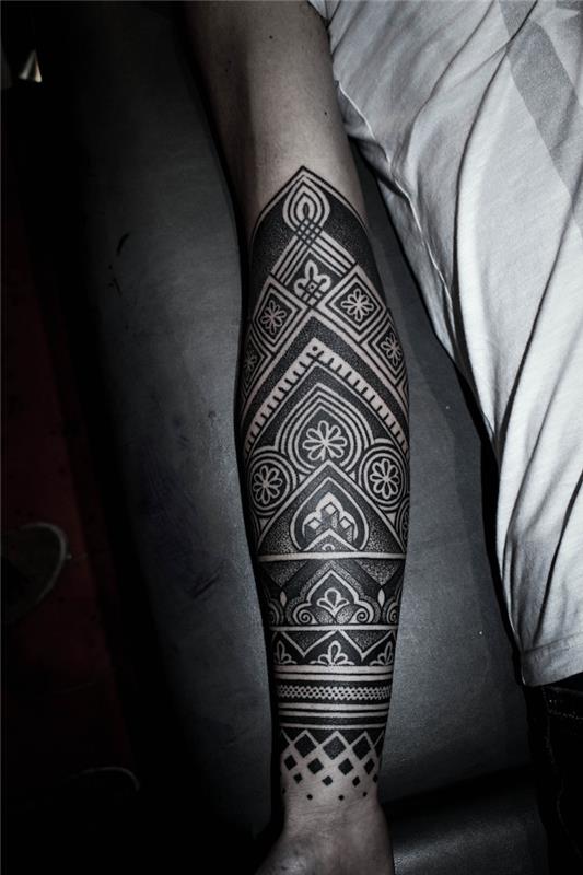 Tatuaggio braccio uomo con disegni e motivi polinesiani