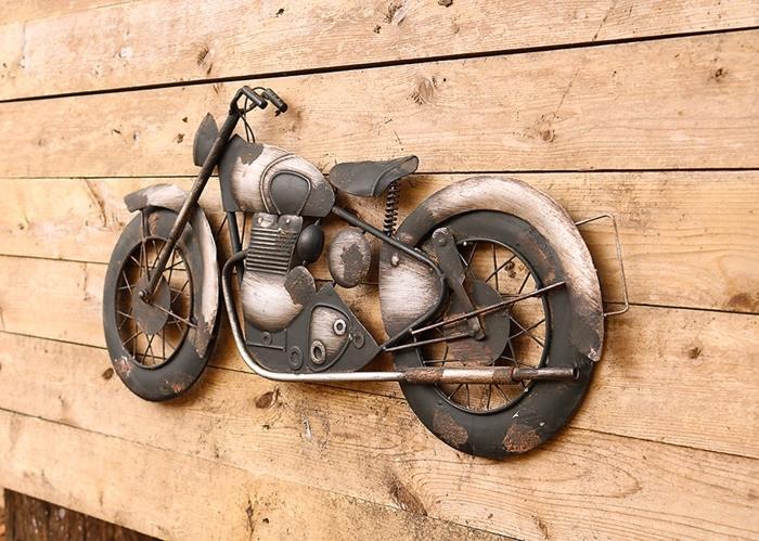 exempel på metallväggdekoration med en motorcykelskulptur som hänger på en ljus trävägg