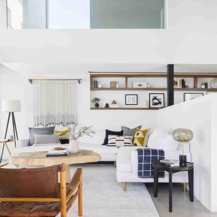 minimalistický dekor s bielymi stenami a dreveným nábytkom, model veľkej rohovej sedačky zdobený vankúšmi