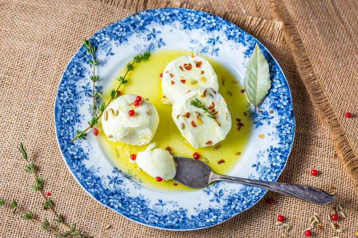 enkla vegetariska aptitretare, skivad mozzarella, i en blå och vit tallrik, med örter och sås