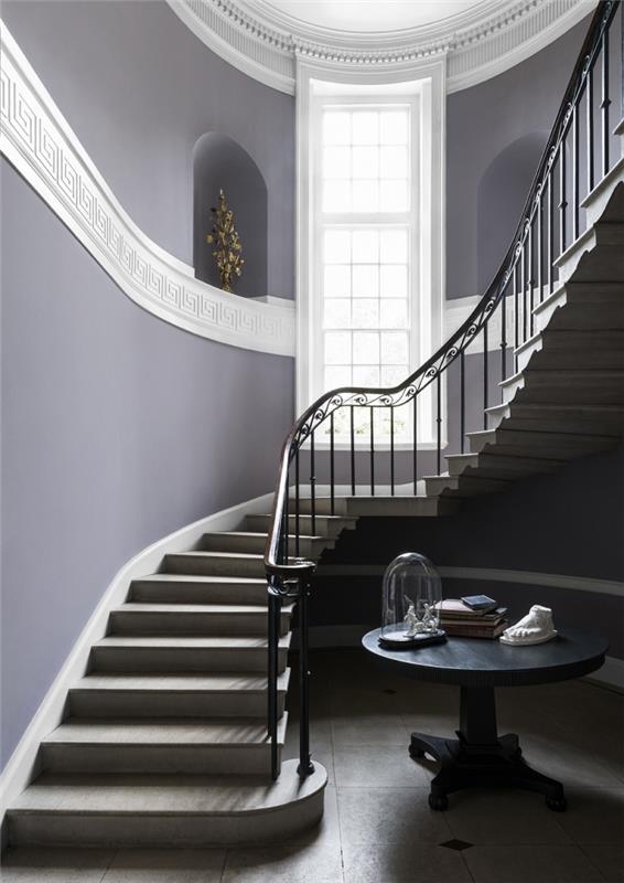 ett rymligt och elegant trapphus med väggar i lila med väggnischer av samma färg och en vit fris som korsar väggen