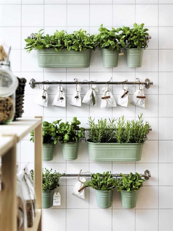 vytvorte v kuchyni malú bylinkovú záhradu pomocou zinkových kvetináčov mandľovo zelenej farby a plátenných vreciek zavesených na nosných tyčiach na stene, na pozadí steny obloženej bmancovými dlaždicami