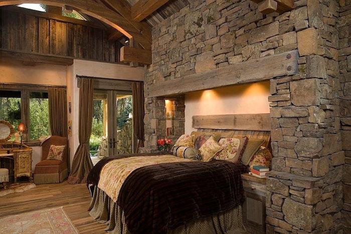 Spálňa v strednom veku v zámockom štýle so starými sivými kamennými múrmi rôznych tvarov a posteľou v kozubovom ráme a drevenom ráme