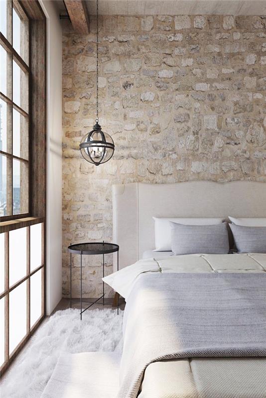 stena spálne s kamienkami alebo imitáciou, drevený rám okna a dizajnérska závesná lampa