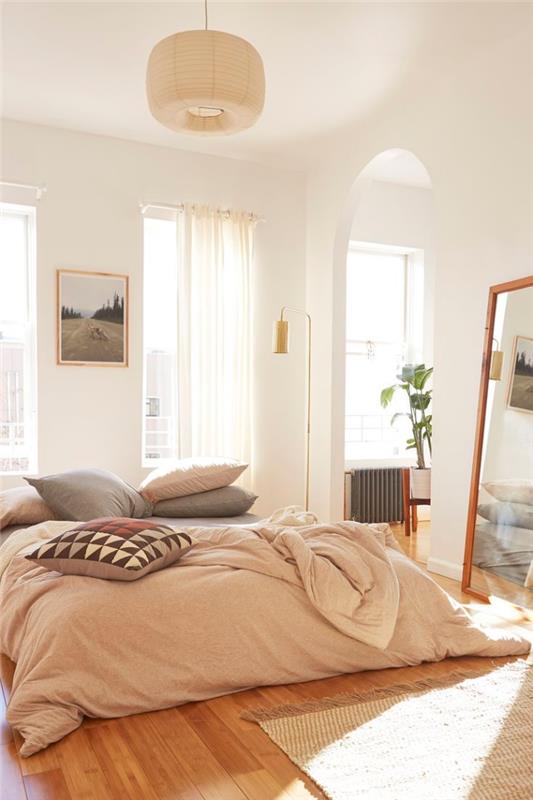 vilka sovrumsmöbler att välja för ett rum i bohemisk stil med en låg säng täckt med kuddar och plädar i neutrala och pastellfärgade nyanser