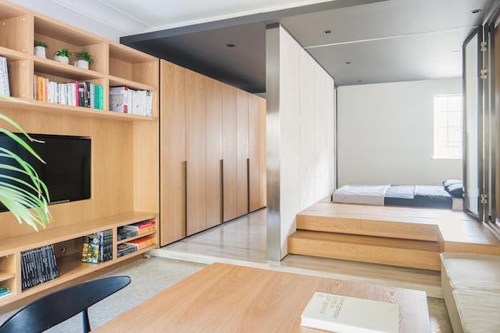 säng på träplattform, träskåp och tv -skåp arrangerade i längd, minimalistisk designidé, japansk stil