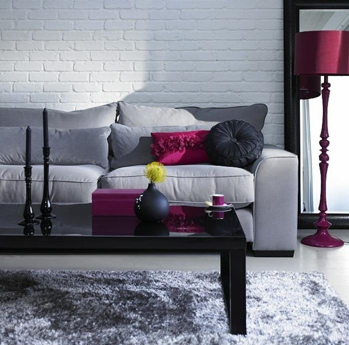 grå soffa, rosa och svarta kuddar, rosa lampstativ, grå färgscheman, svart soffbord