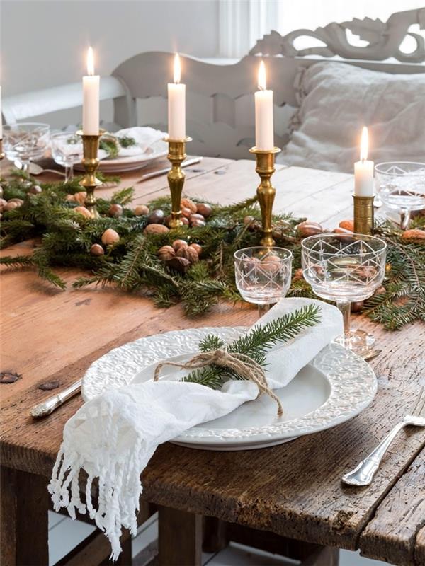 valnötter grönska lövverk grenar dekoration mittpunkt jul en gör-det-själv ljusstake guld rått träbord