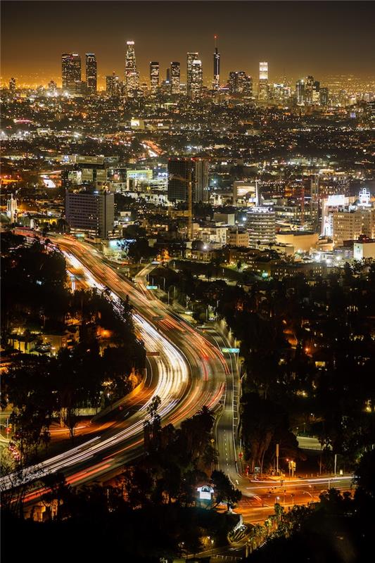لوس أنجلوس في الليل ، صورة جميلة مع أضواء الليل للمباني والسيارات ، وحركة المرور في لوس أنجلوس والاحتياطات البيئية