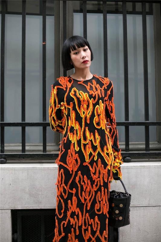 Idea per un taglio ci capelli a caschetto con frangia، abito lungo nero con decorazioni di colore arancione