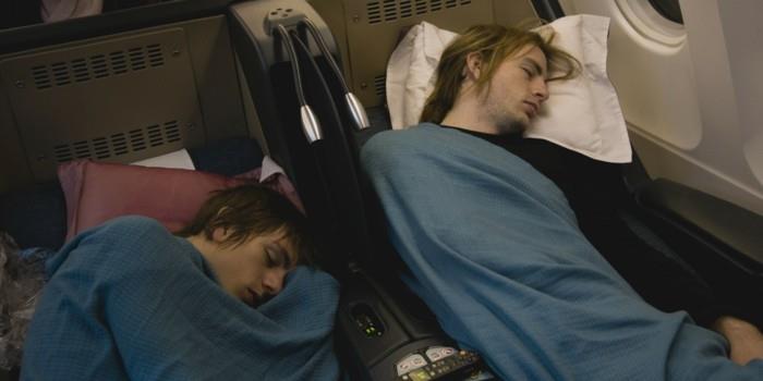 Dvaja mladí muži spiaci v lietadle