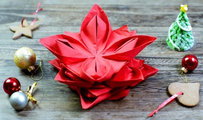 Vianočná technika skladania obrúskov, nápad, ako zložiť obrúsok v kvetinovom tvare, umenie origami s červeným obrúskom