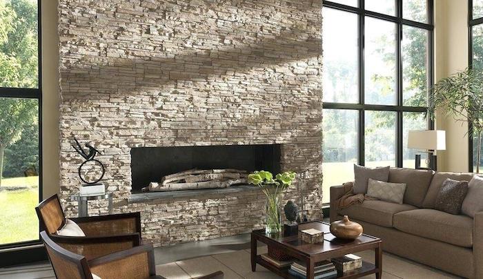 béžový obkladový kameň pokrývajúci stenu a komínový dymovod vo veľkej obývačke s arkierovými oknami