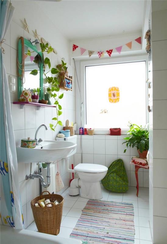 dekoratívna toaleta s farebnými predmetmi pre domácich majstrov, biely model toalety zdobený zelenými rastlinami a ručne vyrobenými doplnkami