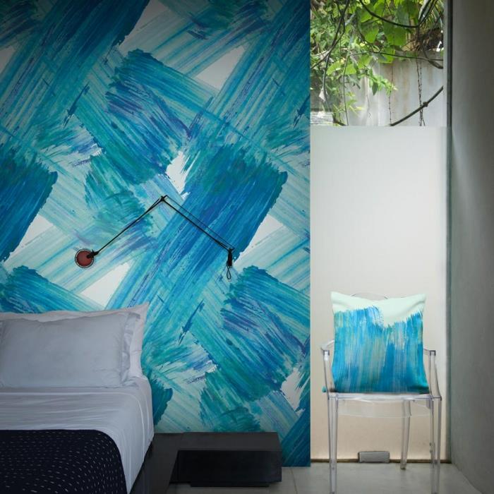 trompe l'oeil tapet, i blått, stora penseldrag på en vit duk, sovrum för vuxna med transparent plaststol och stor kudde i blått och vitt