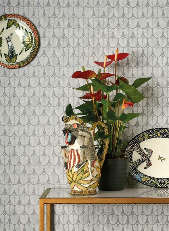 trompe l'oeil tapet i ljusgrått, med rektangulärt bord i guldfärgad metall, dekorativt kinesiskt porslin, svart kruka med en grön blommande växt, dekorativ porslinskatt i svart, rött och gult