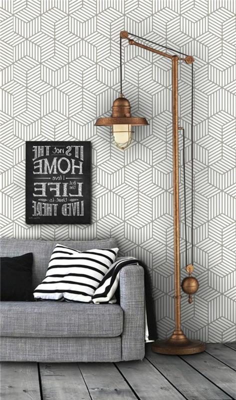 trompe l'oeil tapeter, geometriska tapeter i svart och vitt, hög golvlampa i imiterad kopparmetall i industriell stil, med stor glödlampa, grå soffa, dekorativ panel i svart och vitt med en filosofisk tanke