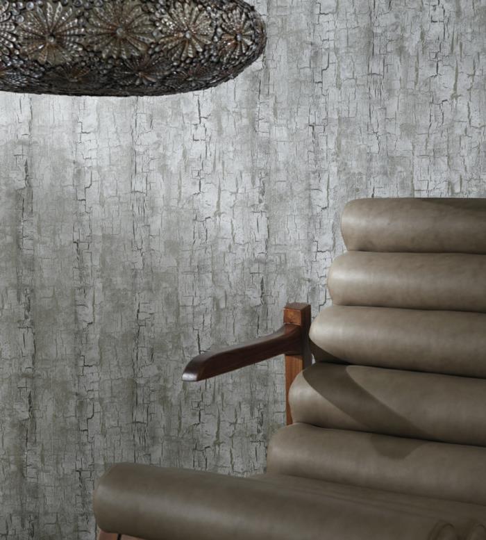 tapeter i imiterad panel, trompe l'oeil tapeter, trädbarkmönster i grå färg, taupe fåtölj i konstläder med effekter