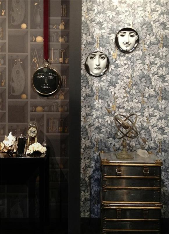 trompe l'oeil tapet, vita och gråa blad, tre fotografier i runda ramar på väggen, metallskåp med dekorativt föremål, svart träskåp