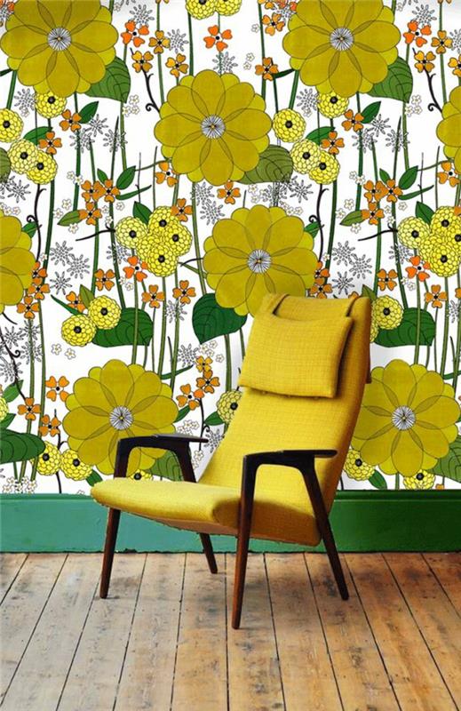 trompe l'oeil tapet med stora gula blommor, stora gröna blad, botten på väggen målad i gräsgrön, rå träparkett i beige, fåtölj i gult, senap med mörkbruna träarmar