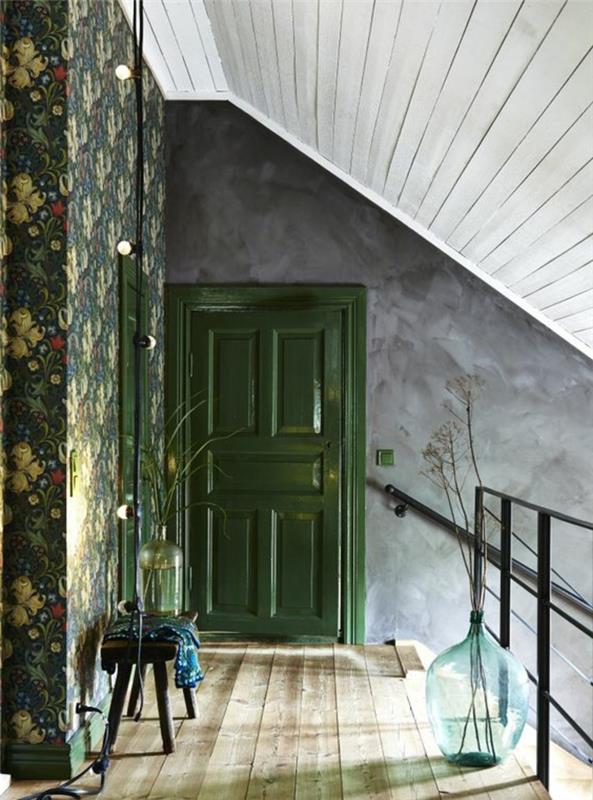 trompe l'oeil tapet på vindsutrymme, frihets tapetvägg, med gula blommor på grön bakgrund, tak med vita balkar, grå vägg, gräsgrön dörr, råbeige parkett, stor vit glasskål