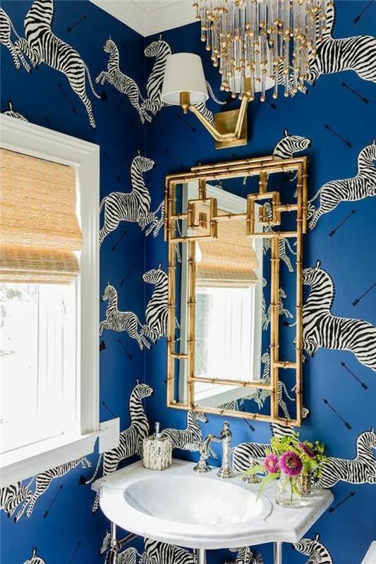 trompe l'oeil tapet i elblått med stora zebramönster i gång, badrum med stor ljuskrona med långa kristallkvastar, vit handfat, i oval och kvadratisk form