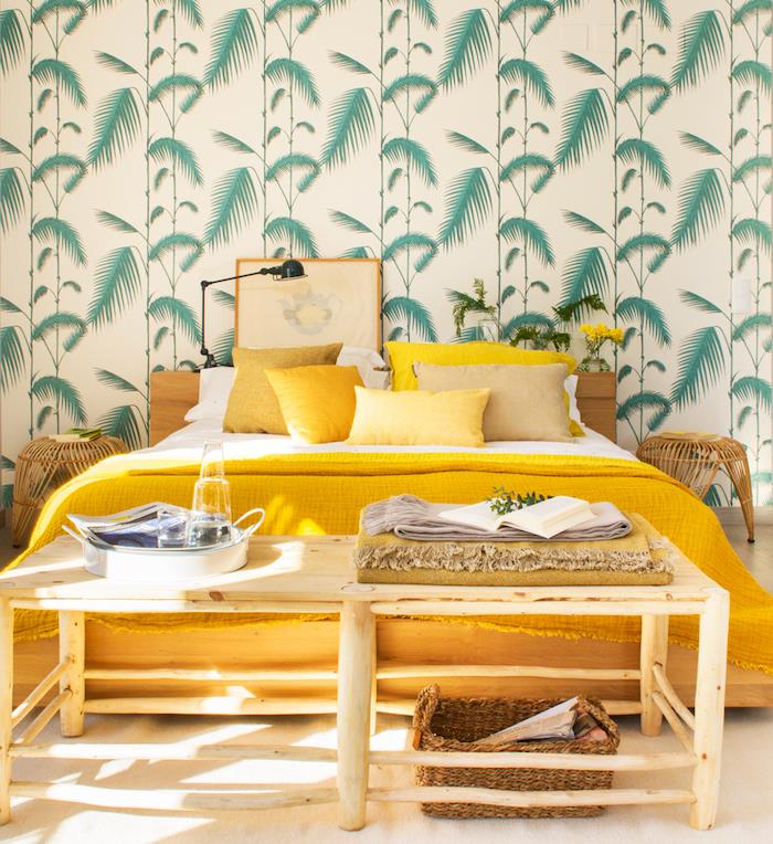 tropisk oas, sovrumslayout, king size -säng med gul filt och kuddar, tropisk mönstrad tapet