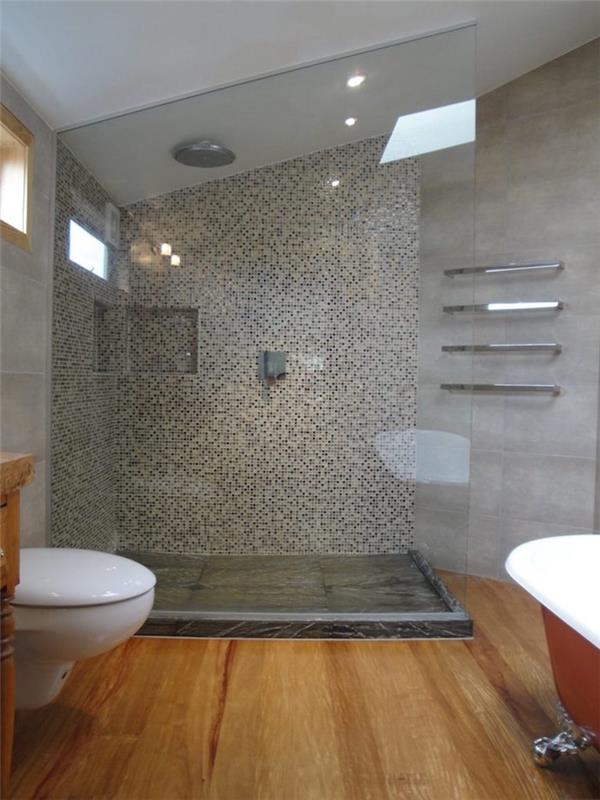 حمام علية حديث بجدار من الإسمنت الرمادي ومقصورة دش وأرضية خشبية مع حوض استحمام قائم بذاته