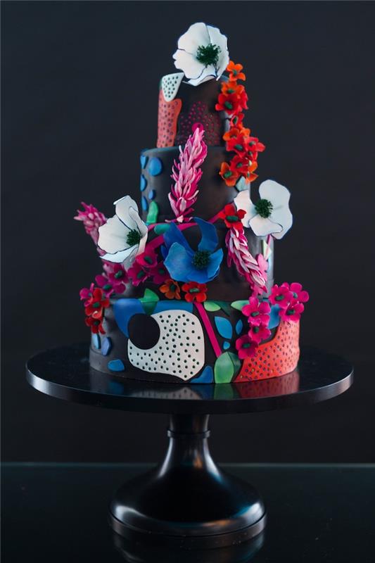 blommig och abstrakt kakdesign på svart sockerpasta och pappersblommedekoration