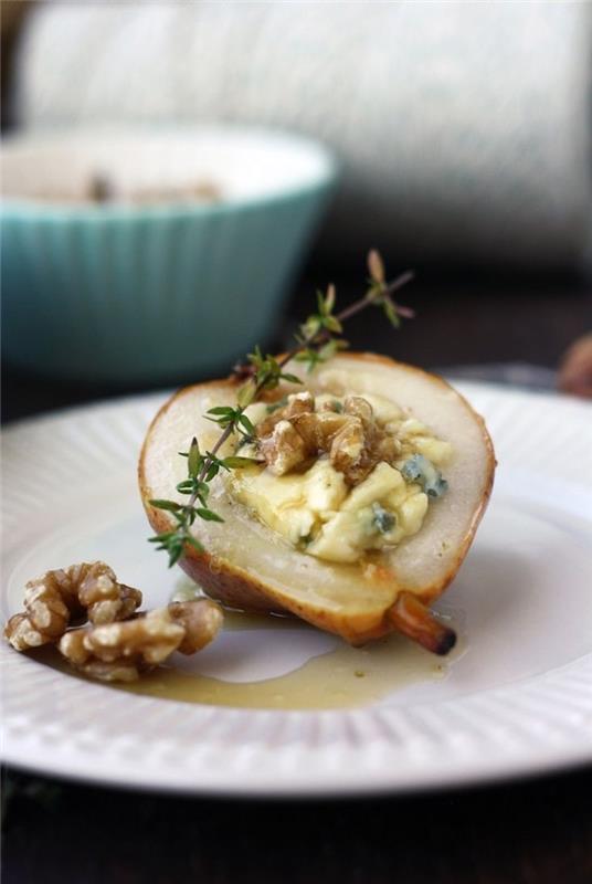 bakat päron, fyllt med nötter och smält ost, enkla vegetariska aptitretare, i en vit tallrik