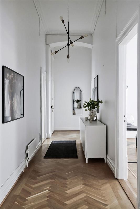 en vit hall i skandinavisk stil med svarta accenter introducerade av små inslag, vit skandinavisk hallinredning