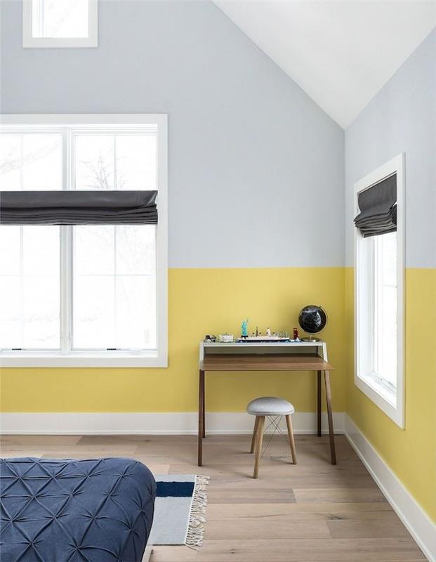 قسم من الجدار الأصفر مع قاعدة وطلاء رمادي ، باركيه خشبي ، غطاء سرير أزرق منتصف الليل