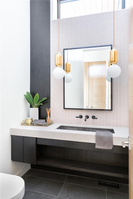 moderný dekor toalety s bielymi obkladmi a podlahou s cementovým efektom, dekor toalety s tmavosivým stenovým panelom