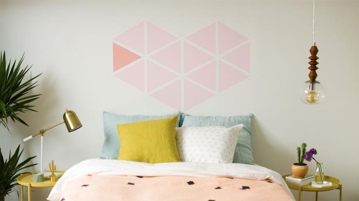 geometrický obraz srdce v trojuholníkoch spálňa maľovanie čelo postele s ružovou nástennou maľbou zlatá nočná stolná lampa