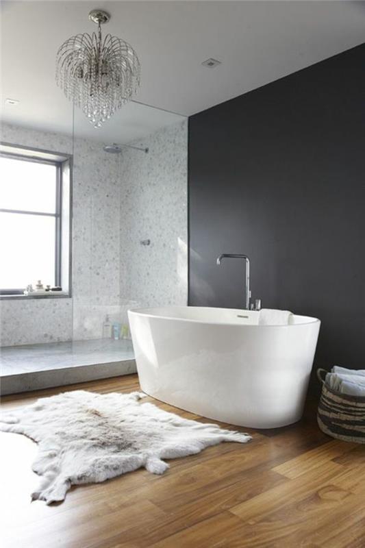 pärlgrått badrum med vitt badkar oval barockkrona i taket nyanserad PVC -parkett
