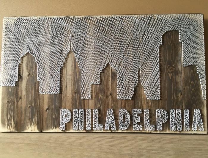 kreativa hobbyidéer med trä och vit tråd, mörk träbrädesmall och vit tråd i form av en stad med bokstäver Philadelphia
