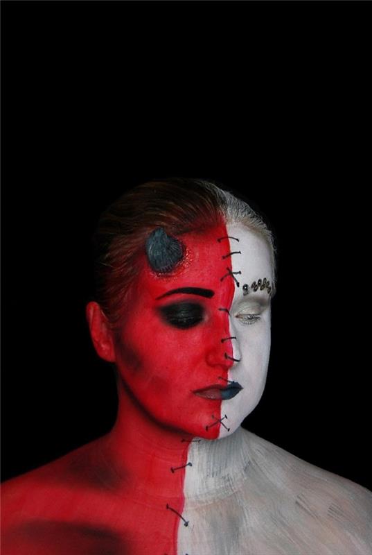konstnärlig demon makeup halvängel halv djävul gjord med röd och vit vattenbaserad ögonskugga, sydd ansikteffekt