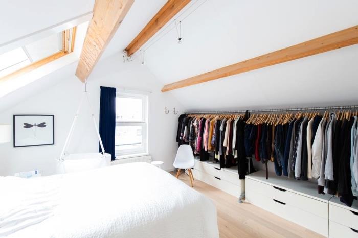 ett vindsovrum i minimalistisk skandinavisk stil med ett öppet sluttande omklädningsrum som följer takets lutning