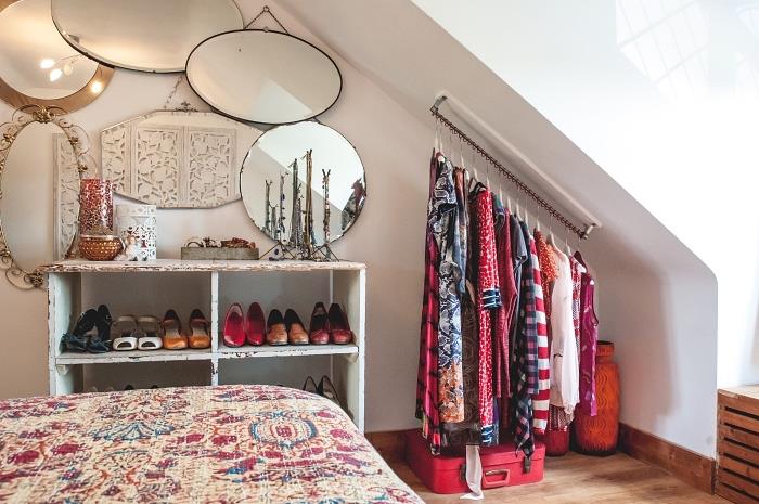 en minimalistisk sluttande garderob i ett hörn av det bohemiska eleganta sovrummet med en bar fixerad på väggen
