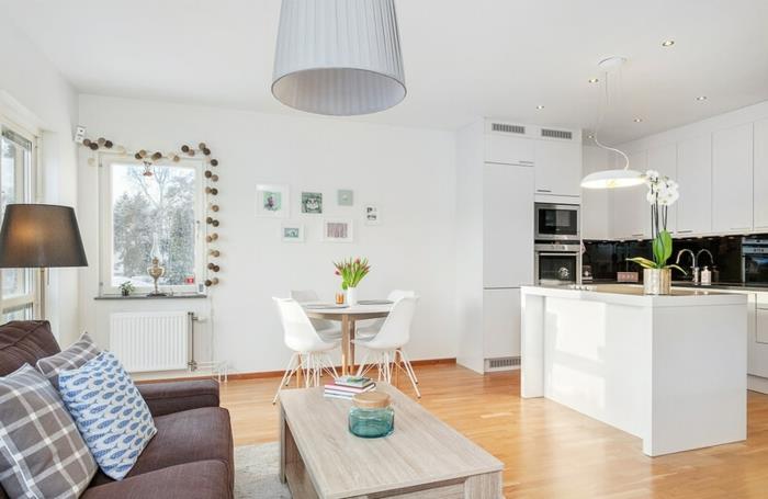 مطبخ صغير من ايكيا للشقة الاسكندنافية الصغيرة ، أريكة رمادية ، طاولة طعام مستديرة ، كراسي بيضاء